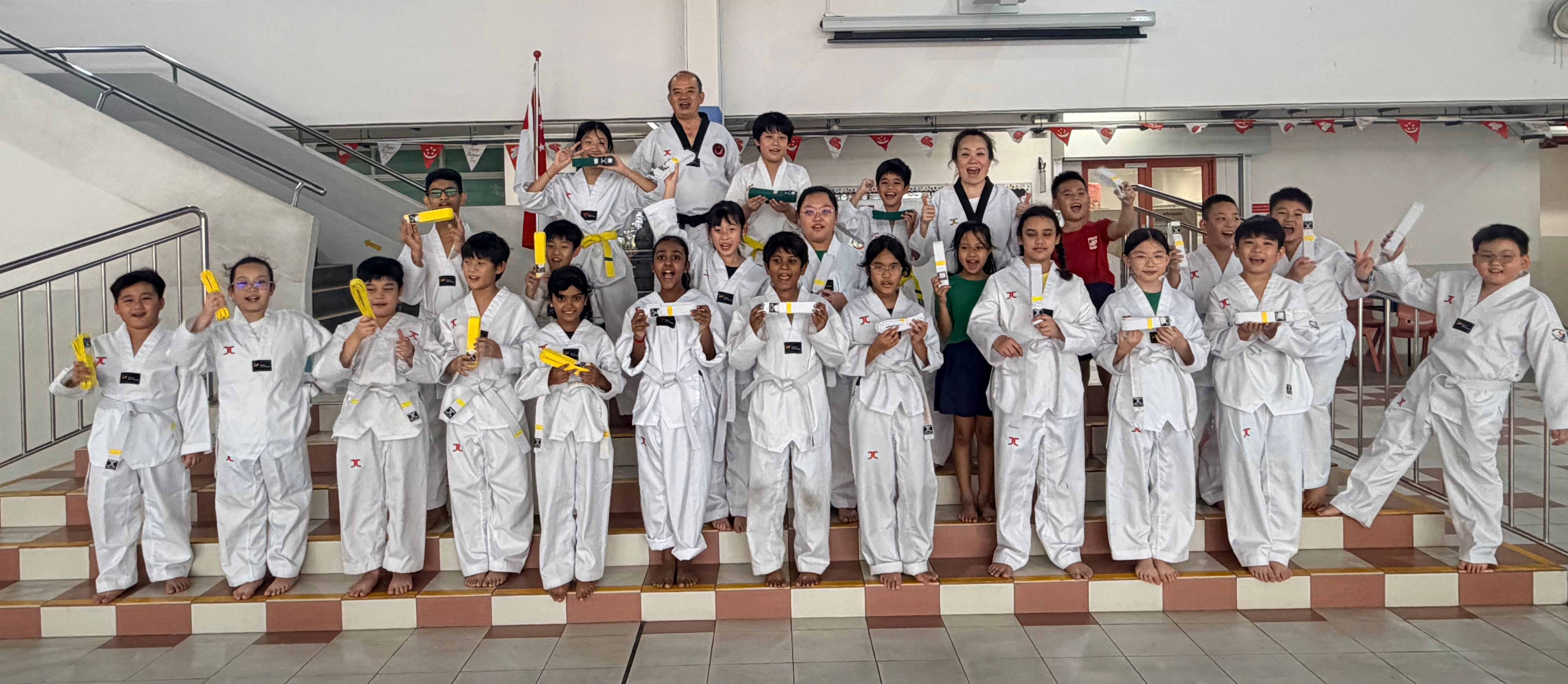 Members of the Taekwando CCA showing off their newly earned belts after the grading test. Group photo taken with the students' coaches.